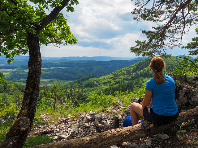 Femme au sommet d'une montagne qui regarde un beau paysage